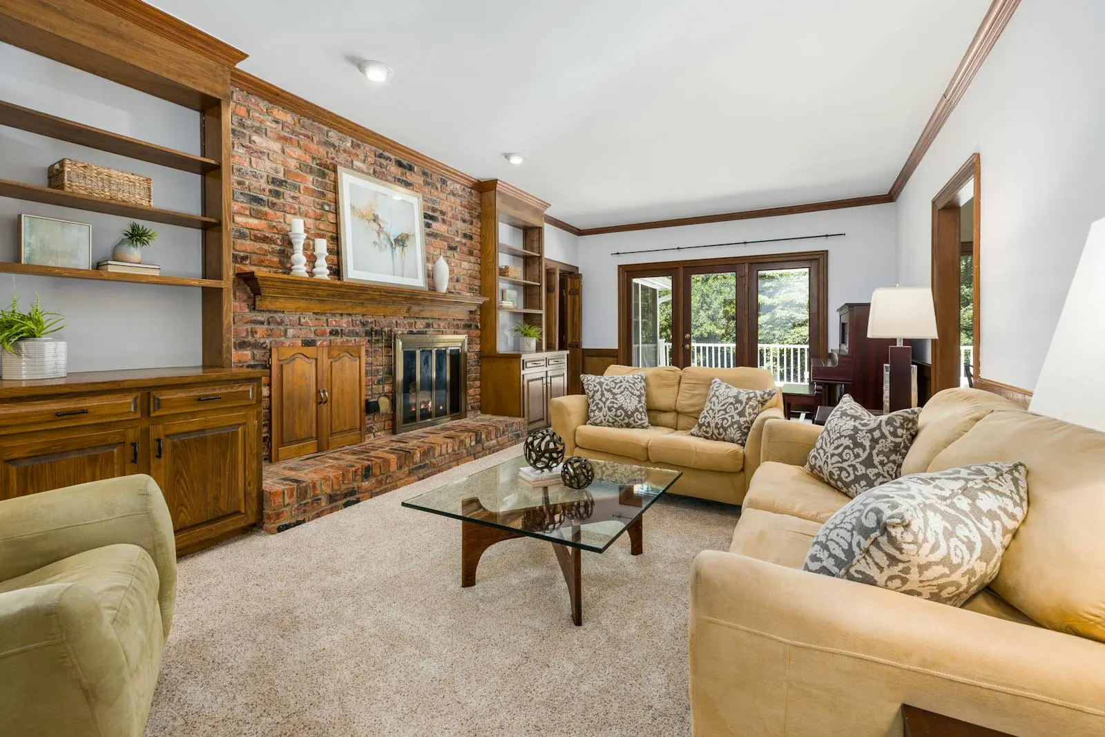 Cozy living room with freshly cleaned beige carpet, brick fireplace, and warm wood built-ins